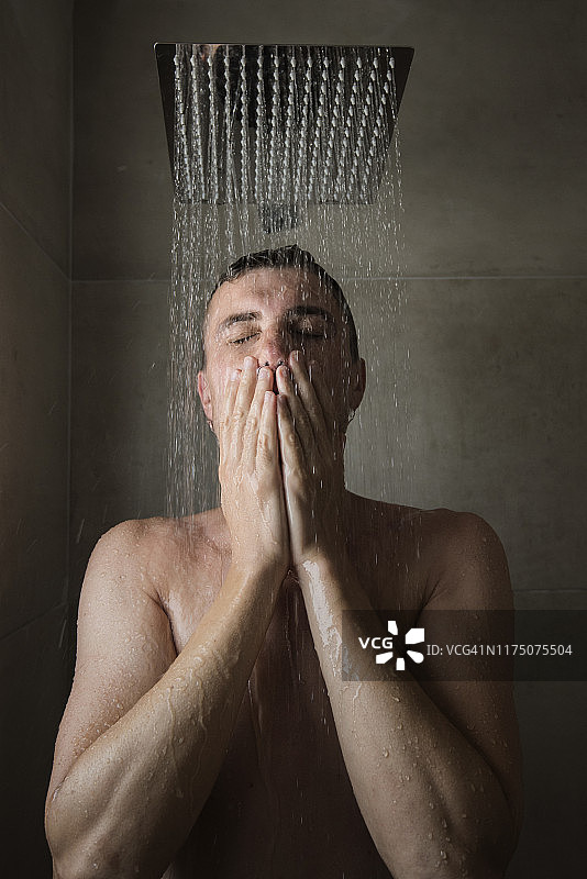 浴室里淋浴下的年轻人图片素材