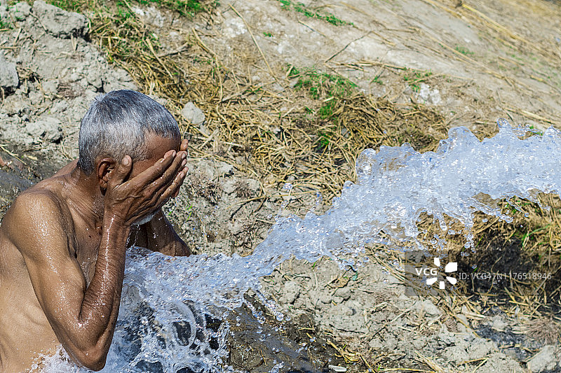 巴基斯坦极端炎热的天气导致一名老村民中暑，正在洗澡图片素材