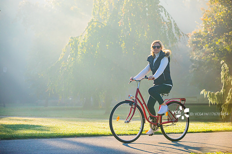 城市自行车-在城市公园骑自行车的妇女图片素材