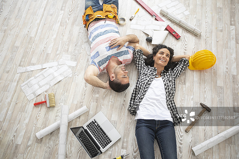 一对夫妇躺在新家的地板上休息图片素材