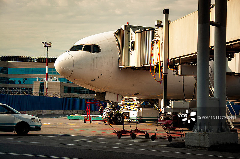 遥控装置与飞机相连。伸缩梯与飞机相连。机场工程系统工作。旅客登机和下飞机。套筒与飞机相连。图片素材