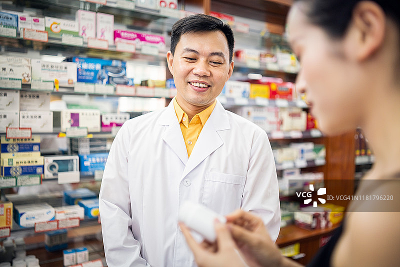 亚洲药剂师向女性顾客介绍药物图片素材