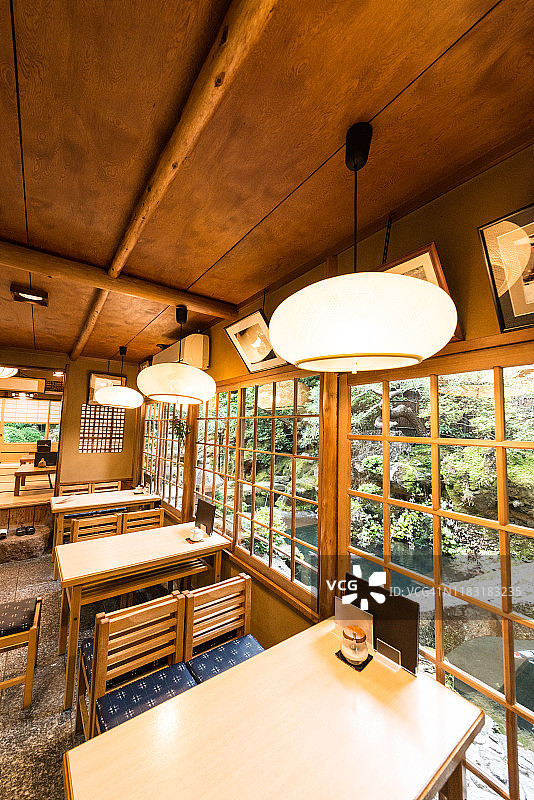 传统的日本餐厅内部与餐桌和花园景观在日本京都图片素材