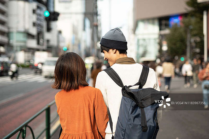 后视图的年轻夫妇走在街上图片素材