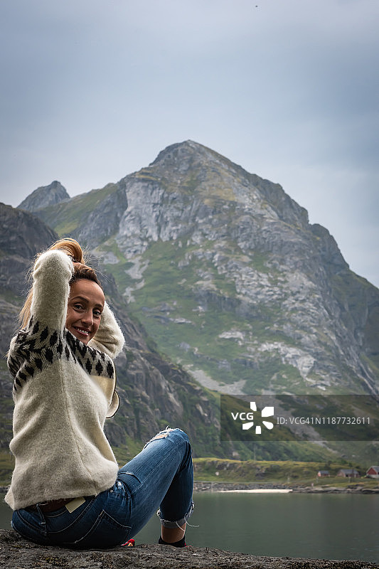女人看着挪威的山脉和峡湾。图片素材