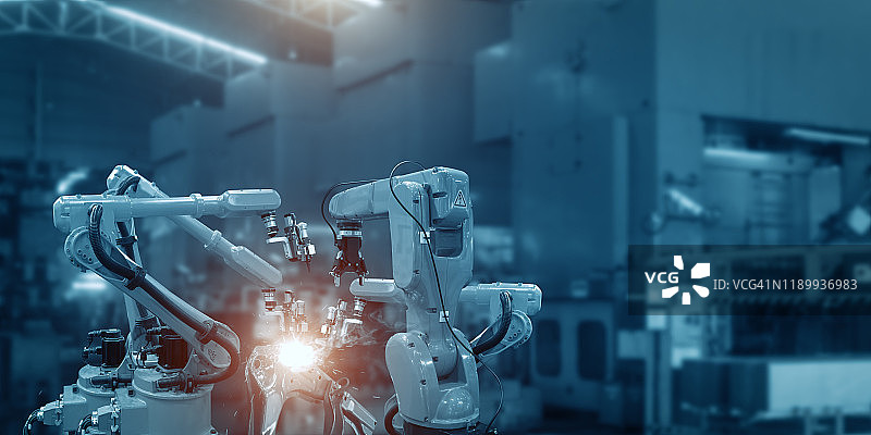 自动焊接机器人机械臂是在现代汽车配件厂工作的。图片素材