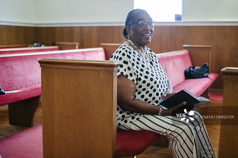 微笑的黑人长者坐在教堂里图片素材