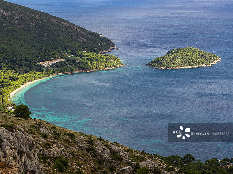 在马略卡岛海岸有一个小岛，山脉，悬崖和蓝绿色的海水图片素材