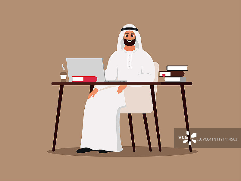 一个年轻的阿拉伯人坐在桌子旁用着笔记本电脑。图片素材
