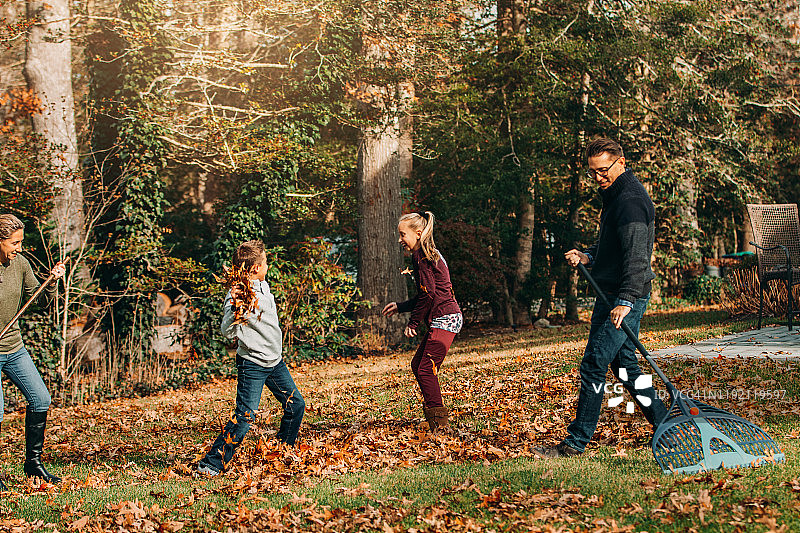 一家人和两个孩子在耙秋叶图片素材