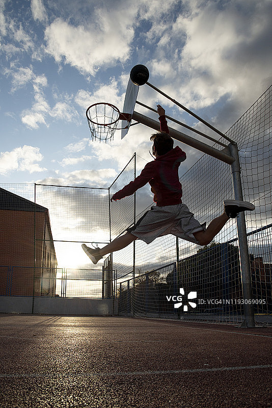 少年在打篮球，对着太阳扣篮图片素材