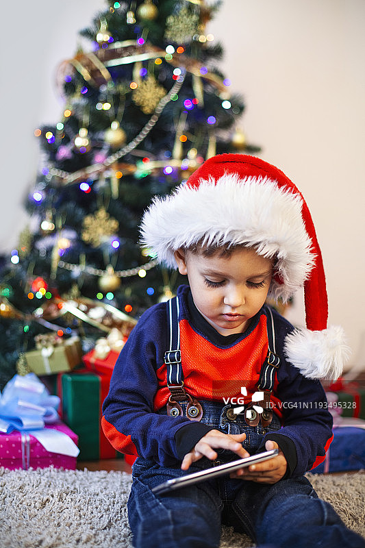 婴儿在圣诞老人的帽子和圣诞礼物图片素材