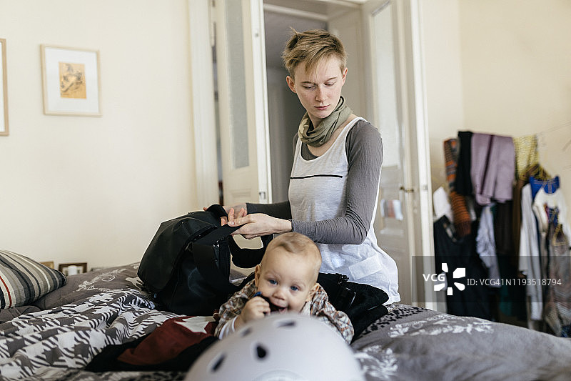 单身母亲与婴儿打包她的包出发前的一天图片素材