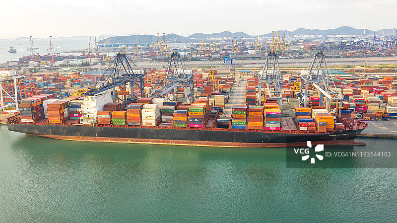 集装箱船在进出口业务和物流。用起重机将货物运到港口。国际水路运输。鸟瞰图和俯视图。图片素材