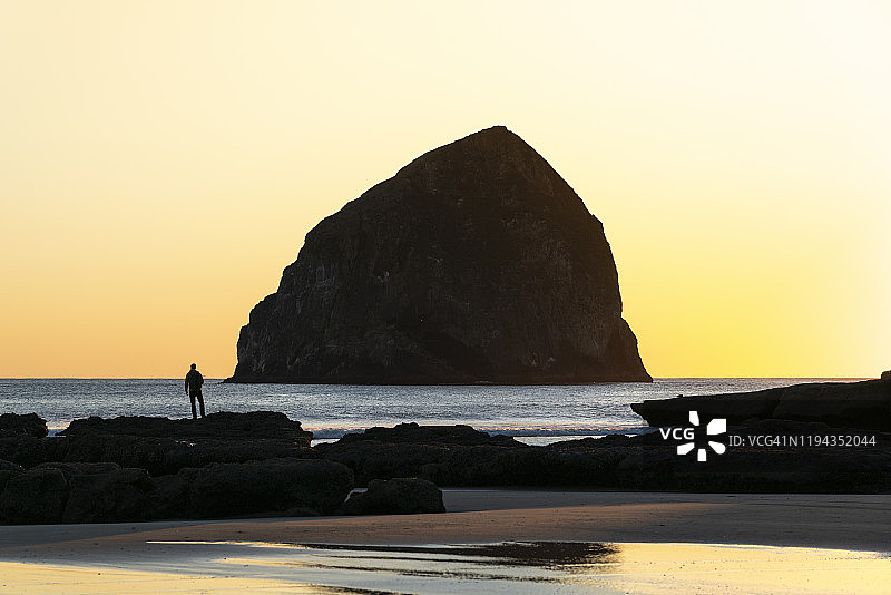 美国俄勒冈州太平洋城，基旺达角，夕阳下的男子。图片素材