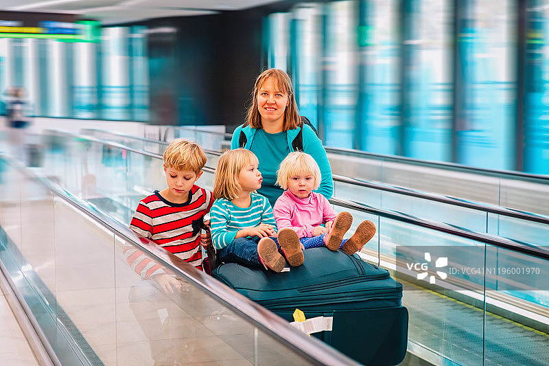 母亲带着三个孩子在机场旅行，一家人一起旅行图片素材