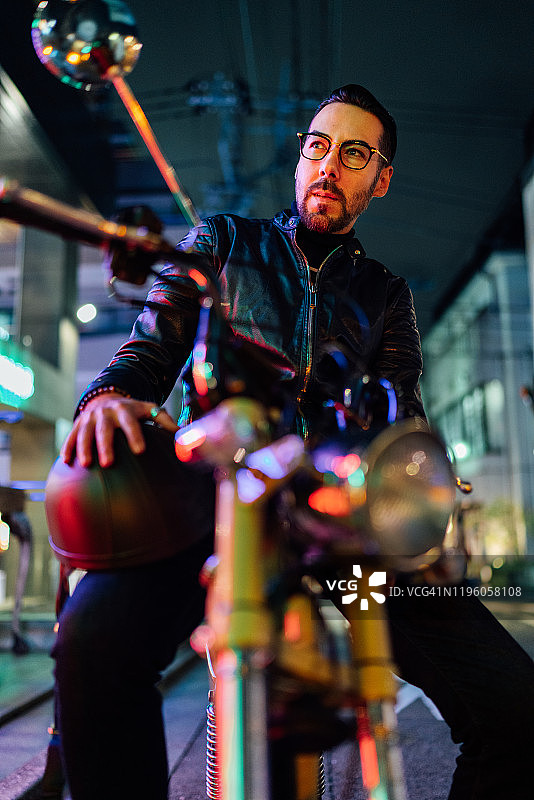 英俊的摩托车骑士在夜晚的肖像图片素材