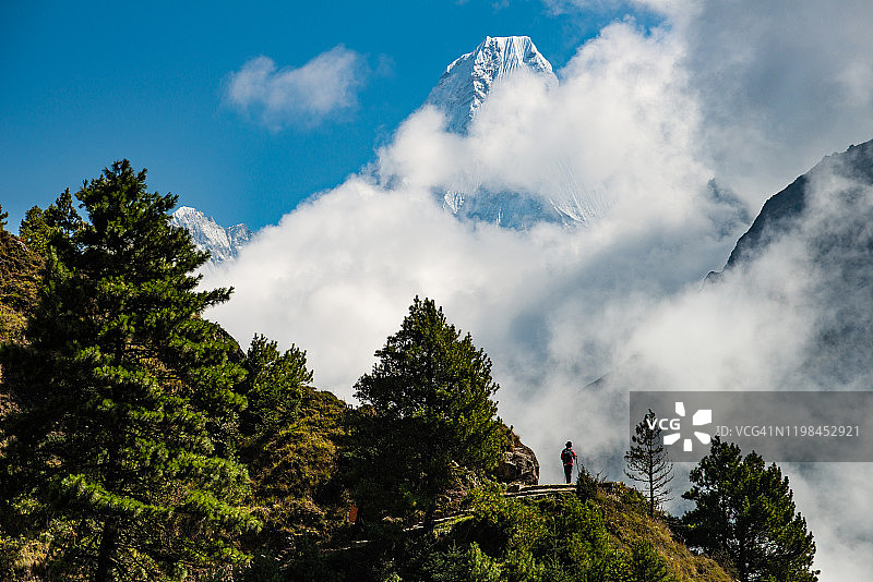 游客在珠穆朗玛峰地区徒步旅行，阿玛达布拉姆山(6812米)隐藏在云后面。图片素材