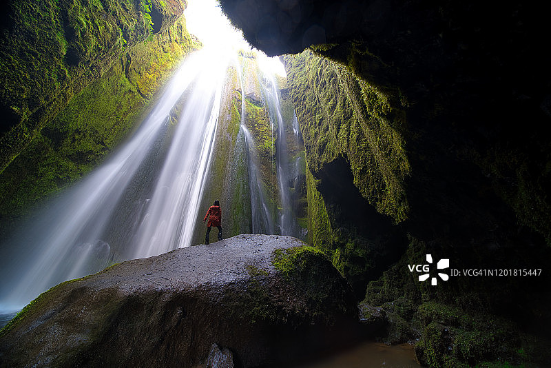 冰岛Gljufrabui，一名女子仰望瀑布图片素材