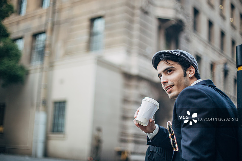 有型的家伙戴着帽子在街上喝咖啡图片素材