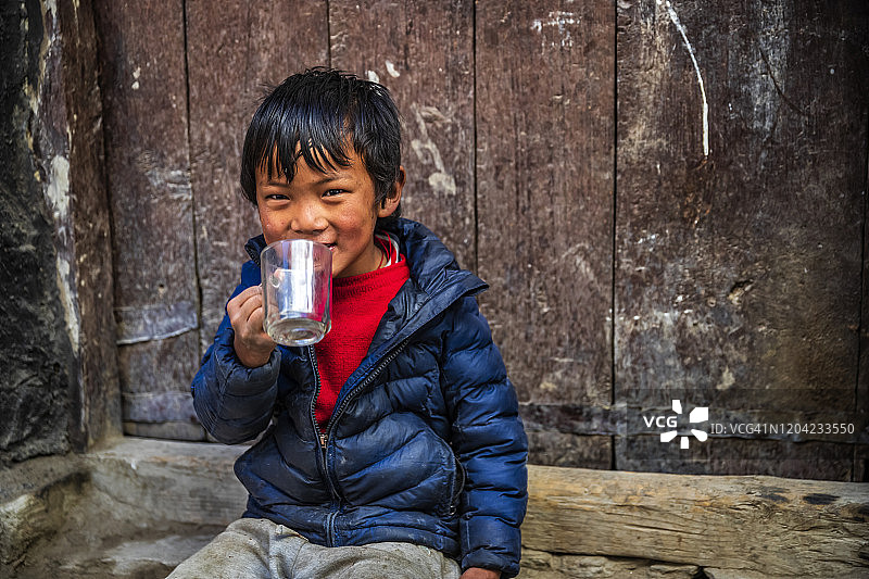 西藏小男孩喝茶的肖像，上野马，尼泊尔图片素材