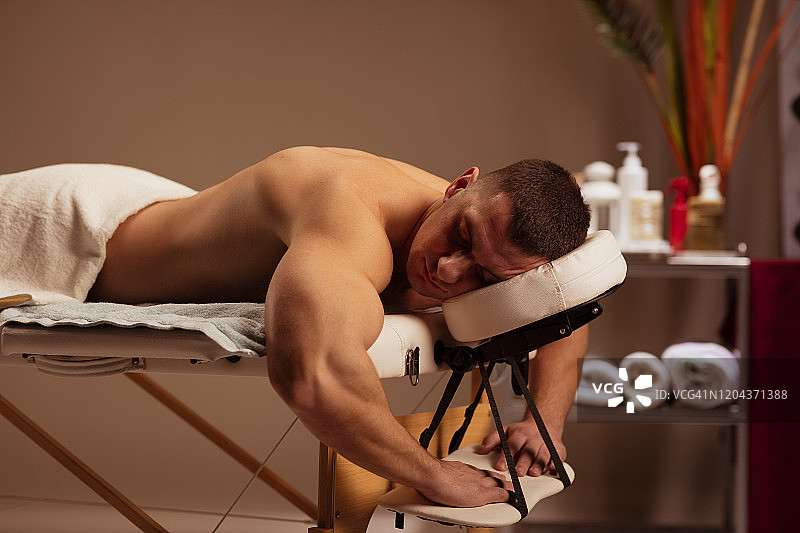 男人享受，放松后在健康水疗按摩治疗。图片素材