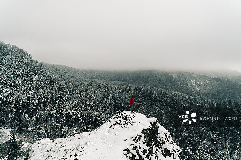 一个年轻的女人站在哥伦比亚峡谷的雪峰上图片素材