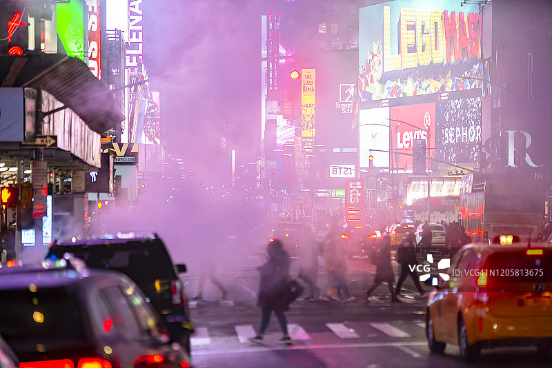 2020年1月14日，美国纽约，夜晚，人们穿过大道，曼哈顿中城的车流在漂浮的蒸汽中穿过时代广场。图片素材