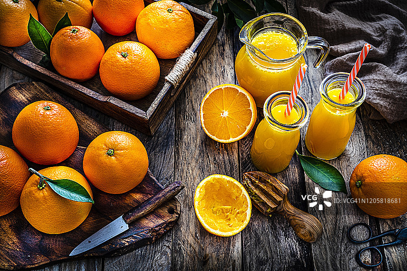 两个自制的橙汁瓶从上面质朴的木桌上射下来图片素材