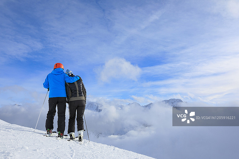 业余冬季运动高山滑雪。朋友女人和男人滑雪者在阳光明媚的滑雪场滑雪。高山雪景。阿尔卑斯山，欧洲，意大利。图片素材