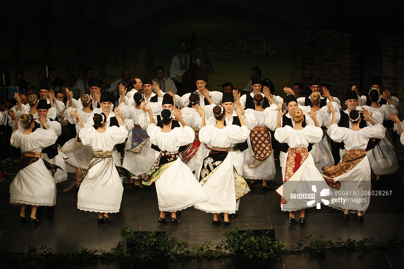 罗马尼亚舞者穿着传统服装，表演一种民间传统舞蹈。图片素材