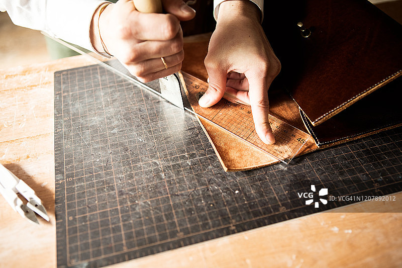 年轻的皮革工匠正在做一个包图片素材