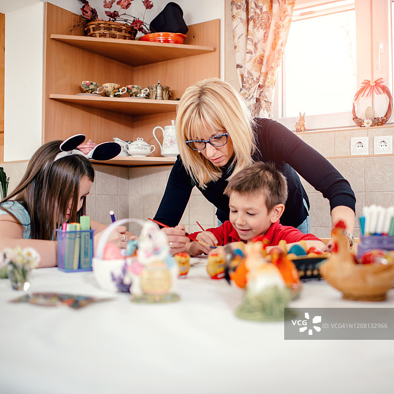 快乐的妈妈和孩子们在家里画复活节彩蛋图片素材