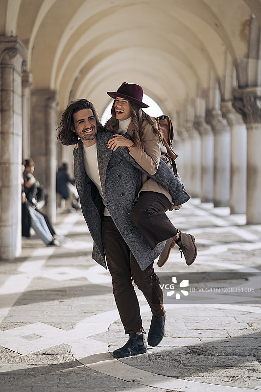 在意大利威尼斯，一个年轻人背着他的女朋友图片素材