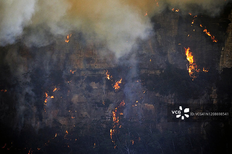 森林大火，野火带着火焰爬上陡峭的砂岩悬崖岩壁，澳大利亚蓝山图片素材