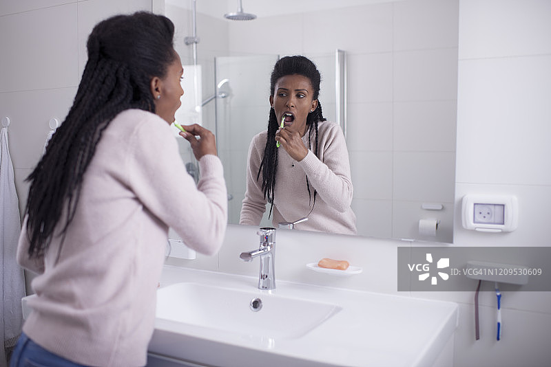 牙齿健康。一个女人在浴室里刷牙。图片素材