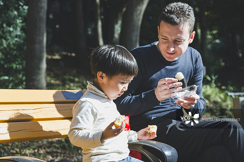 爸爸和儿子在公园里吃午饭图片素材