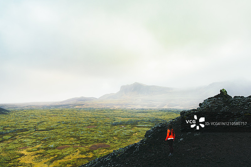 女游客在冰岛山顶欣赏风景优美的火山景观图片素材