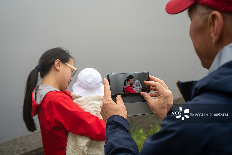 在挪威卑尔根，爷爷在给妈妈和宝宝拍照图片素材