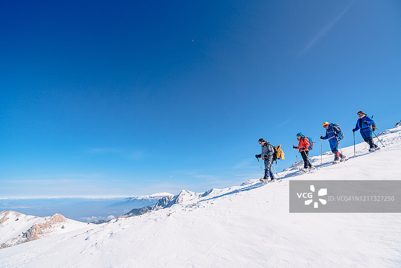 冬季，高山登山队正徒步前往这座高海拔山脉的顶峰图片素材