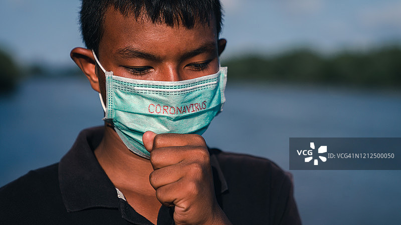 冠状病毒的概念。亚洲小男孩戴口罩保护冠状病毒。2019冠状病毒病暴发时戴口罩咳嗽的儿童。图片素材