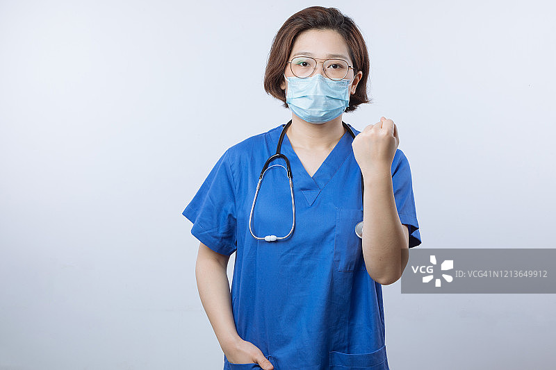 亚洲女医生戴着口罩握着拳头图片素材
