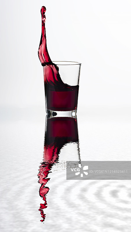 一杯水晶葡萄酒在水中倒映时产生的冲击力。图片素材