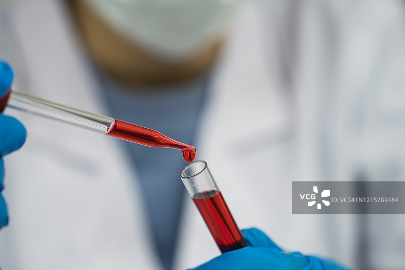 在实验室里，科学家手拿着带血的试管。图片素材