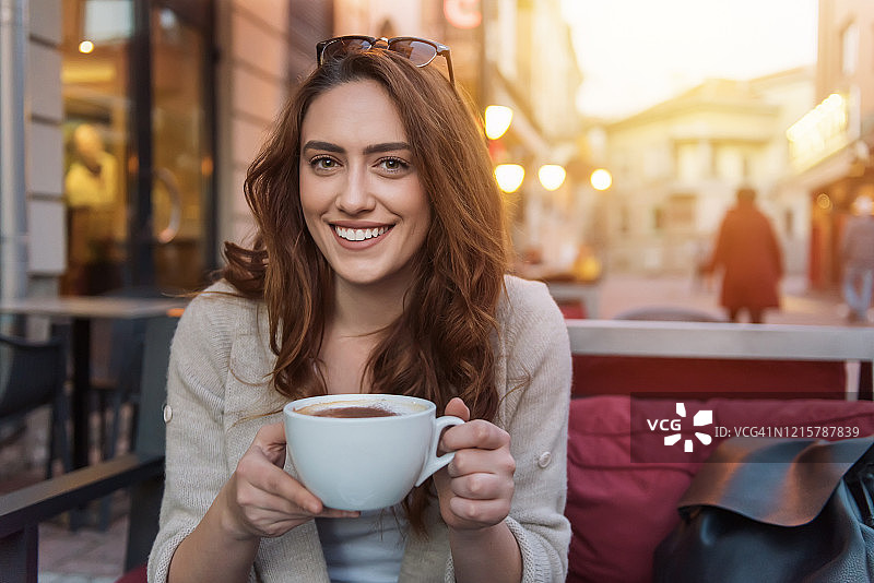 拿着一杯咖啡微笑着的女人图片素材