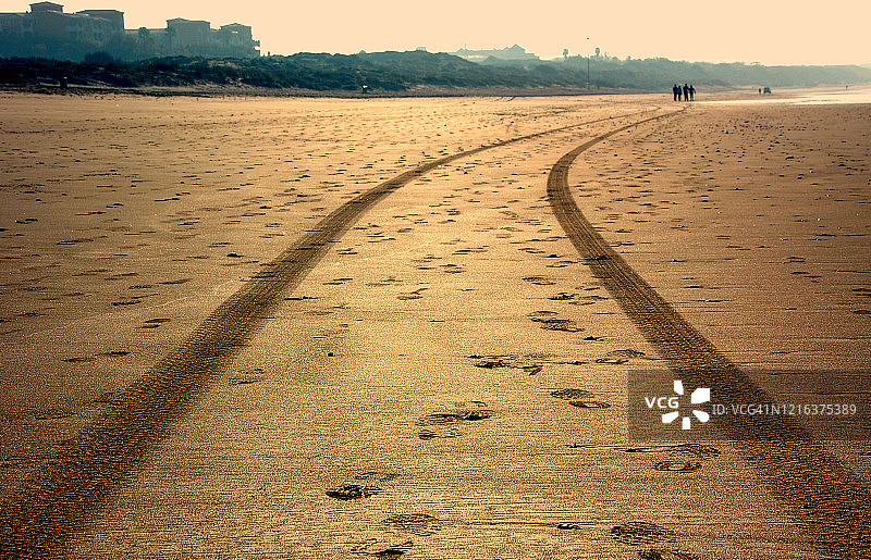 日出-汽车在海滩上的踏痕图片素材