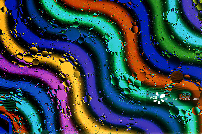 油和水滴在弯曲的彩色线在背景。工作室形象，抽象设计图片素材