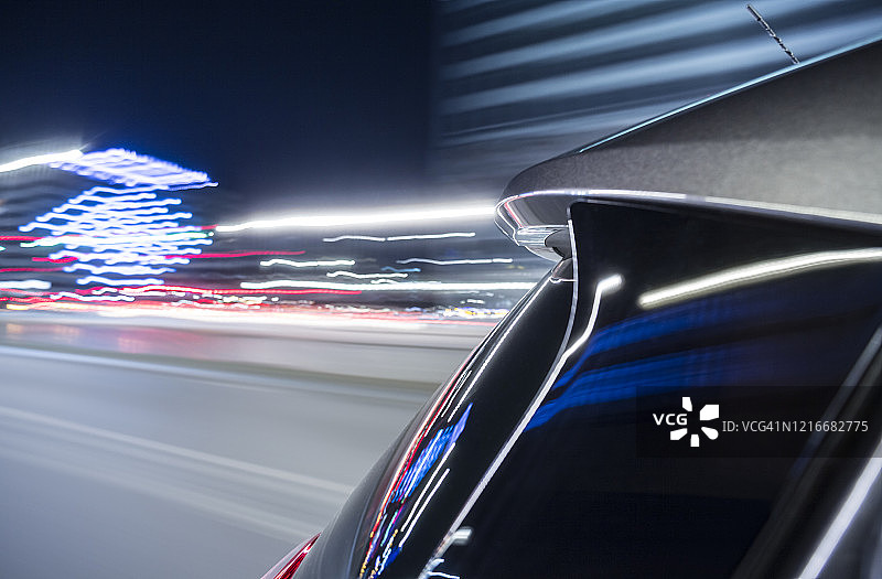 电动汽车在灯火通明的城市里快速行驶，而夜晚则在大街上。图片素材