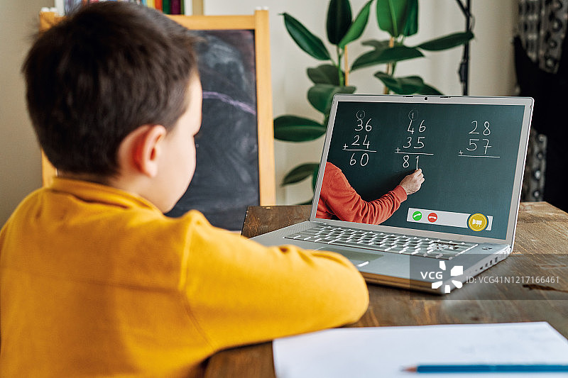 6-7岁可爱的孩子从电脑学习数学。图片素材