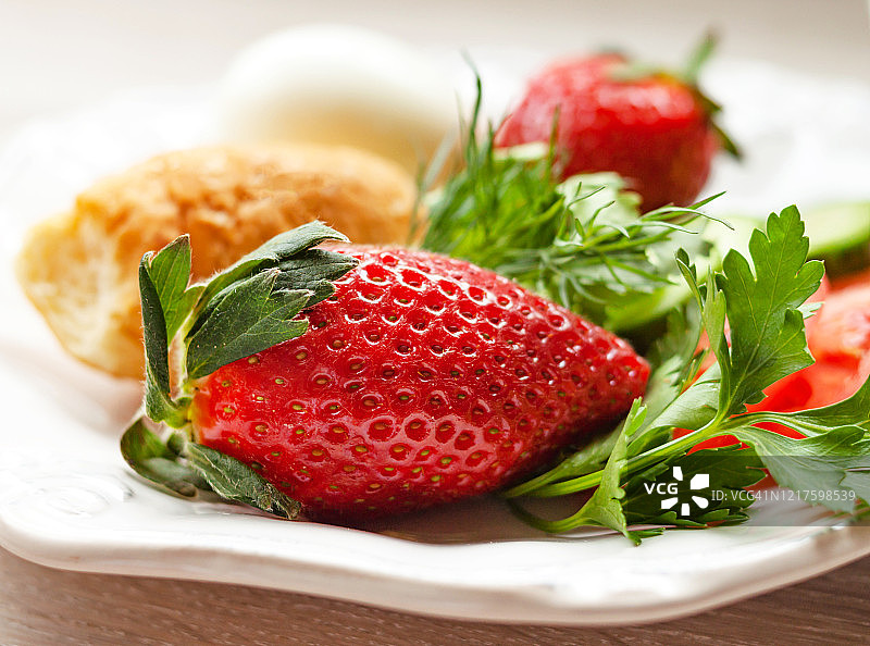 春季健康早餐理念。鸡蛋，牛角面包，新鲜草莓，蔬菜，绿色植物图片素材